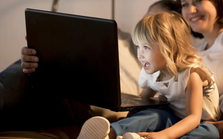 Enfant captivé par un écran d’ordinateur.